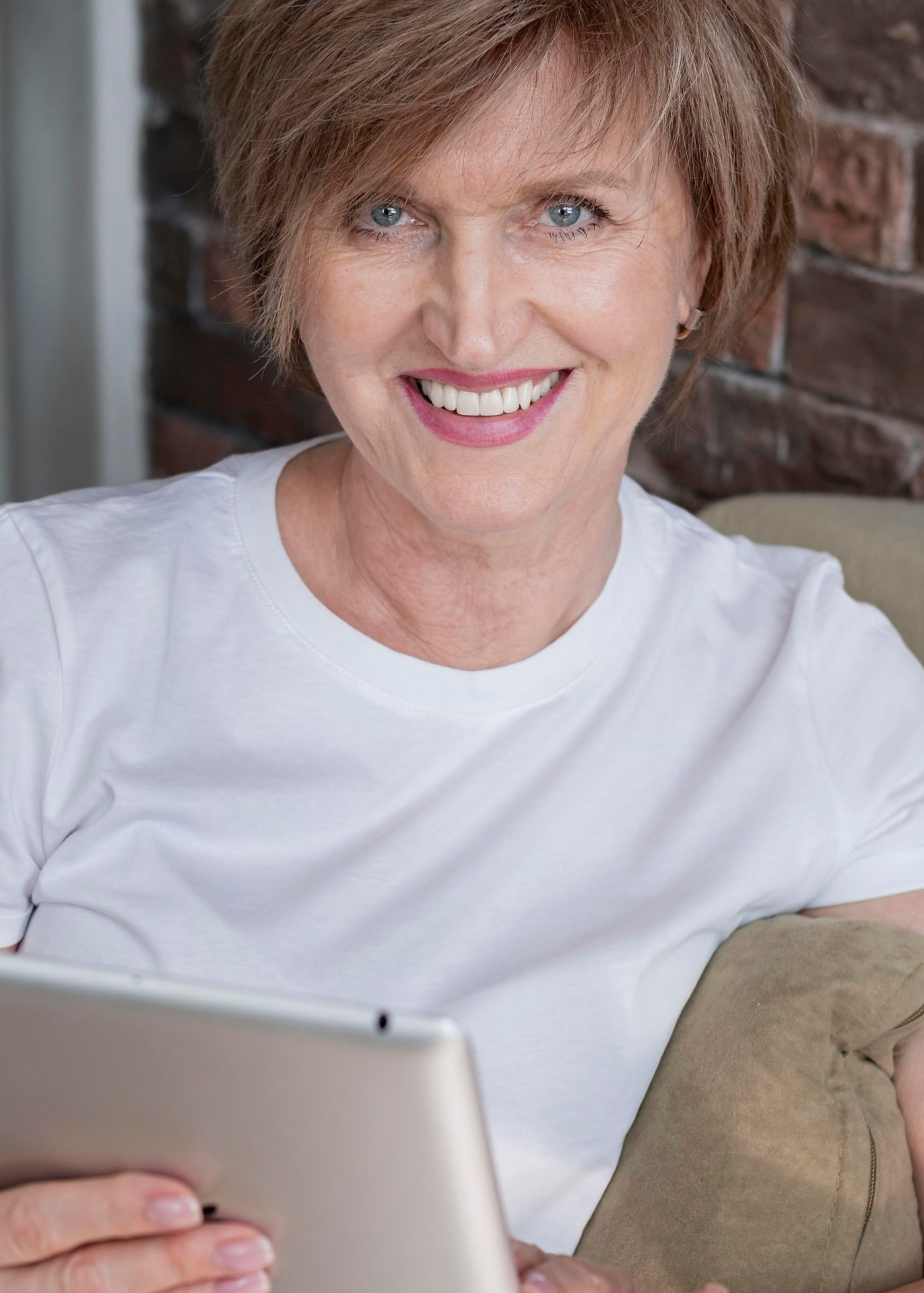 Woman in her fifties smiling while using the MenoCircle app on a tablet